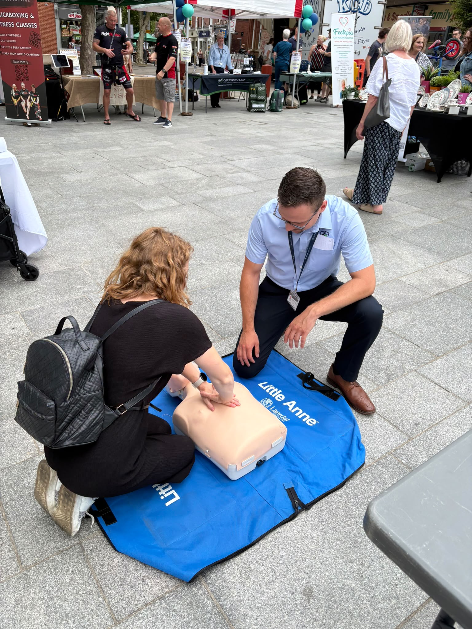 A learner practising CPR on a training manikin with an instructor