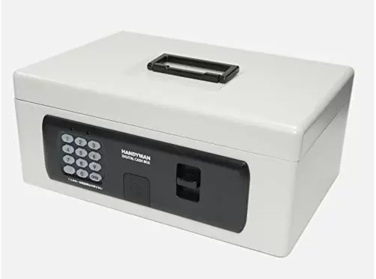 白い背景に、斜め前から捉えたライトグレーのポータブルデジタル金庫。前面には黒い操作パネルがあり、左側に数字のテンキー、中央に「HANDYMAN DIGITAL CASH BOX」の白いロゴ、右側に開閉用のラッチが配置されている。天面には黒い折りたたみ式の取っ手が付いており、角が丸みを帯びたコンパクトなデザイン。