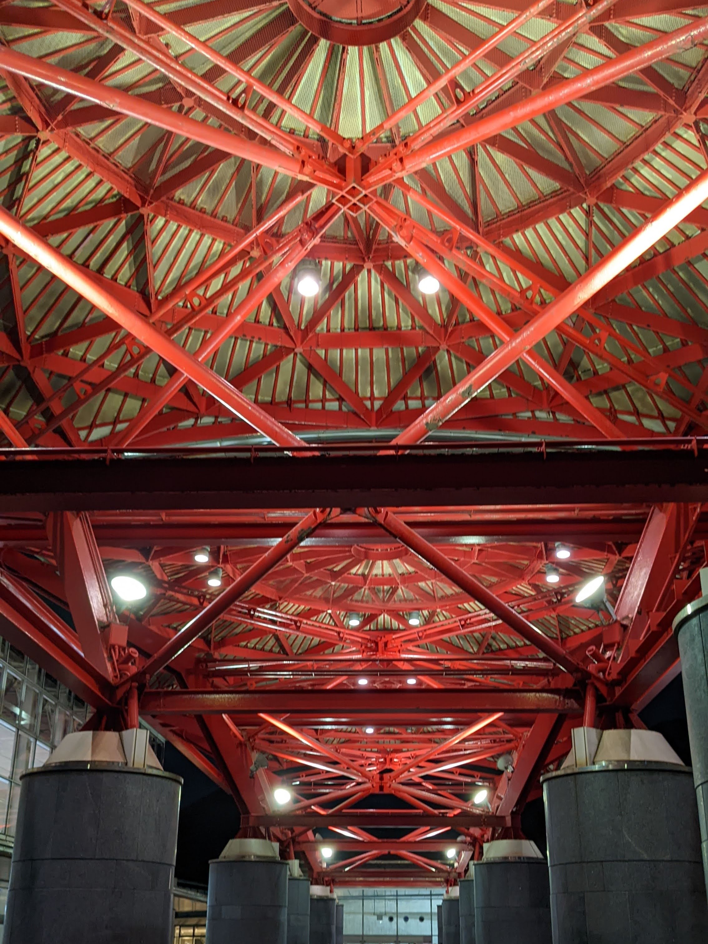 [写真]赤いトラスの天井と、イベントホール入口を望む。