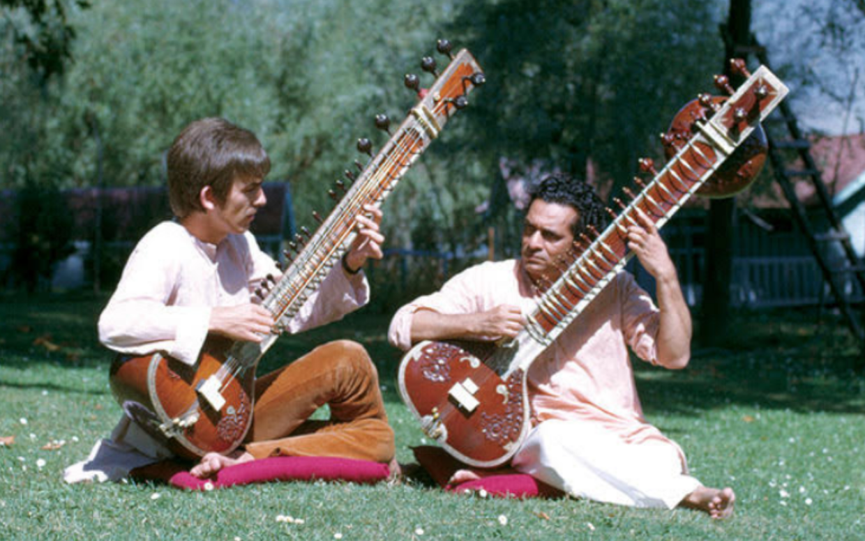 Figure 1: Sankar (R) teaching Harrison (L) to play the sitar [15]